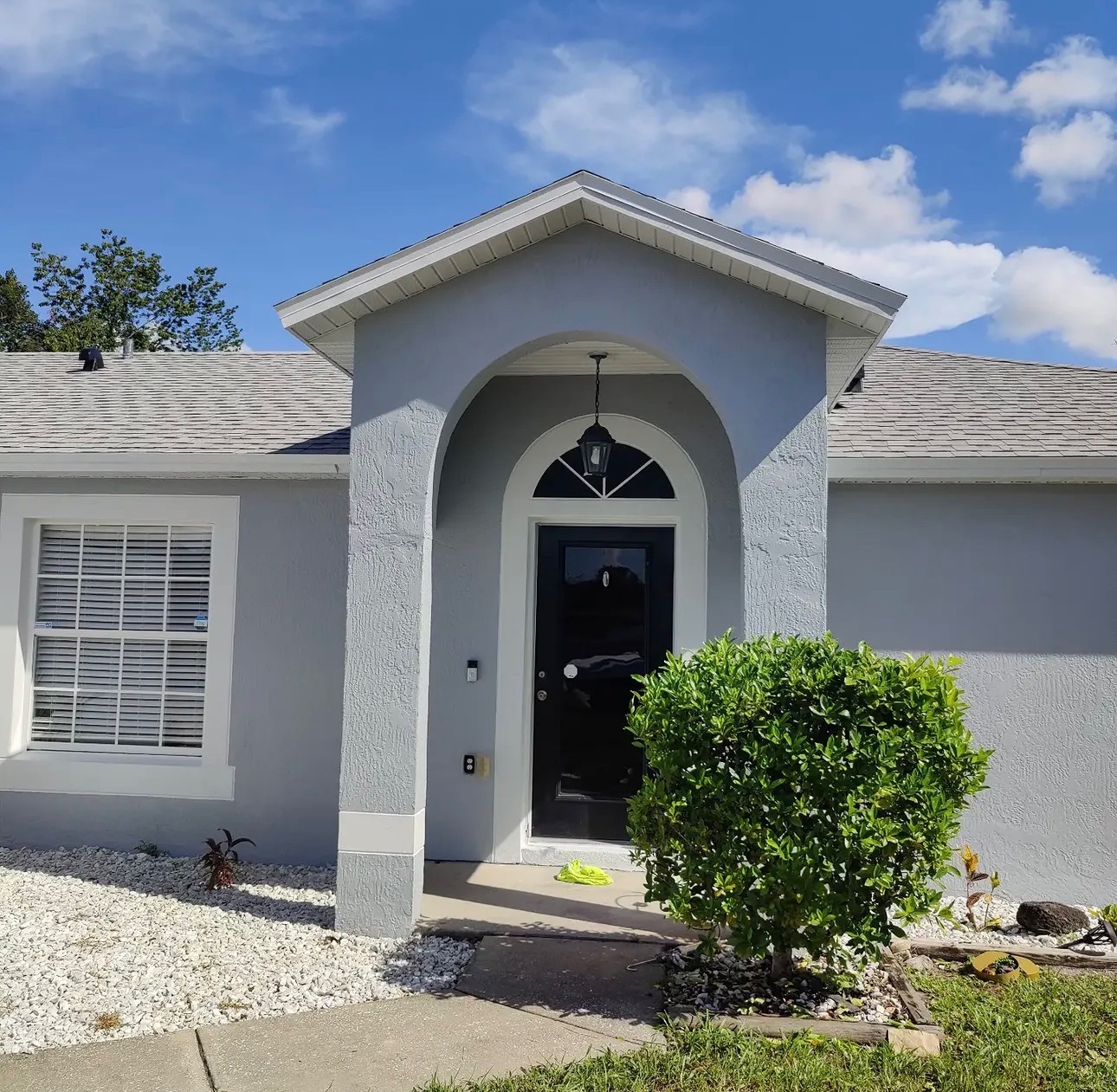 Freshly painted gray exterior with a black front door by Jired Painters